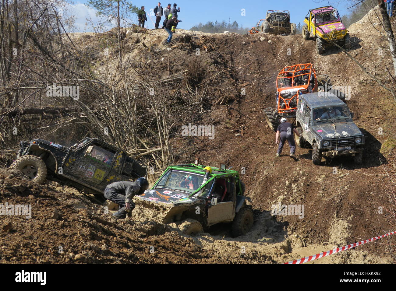 Zwei Off-Road-Autos in einem schlammigen Graben steckengeblieben, Beifahrer sind Stahldraht, checkihg Räder, vier Geländewagen bergab in einem Schlamm fahren Stockfoto