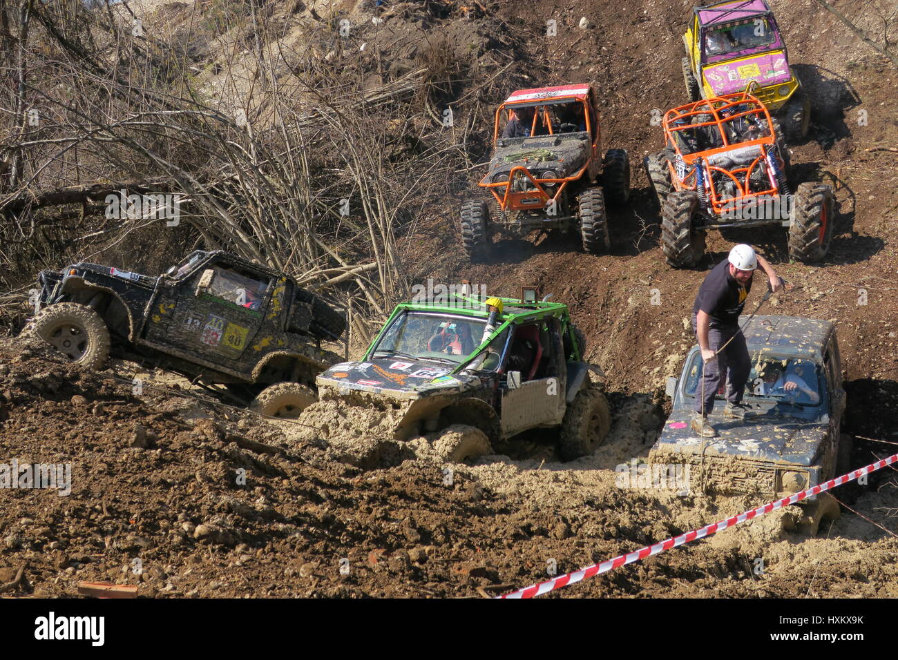 Drei Off-Road-Autos in einem schlammigen Graben stecken geblieben, Stahl Draht am Bagger, Co-Treiber befindet sich auf der Motorabdeckung, drei Geländewagen fahren bergab Stockfoto