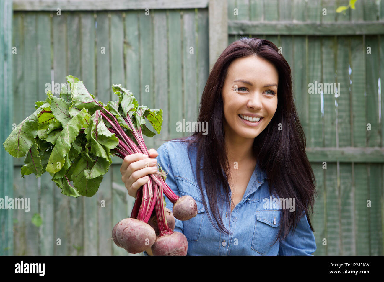 Porträt einer lächelnden vegetarisch-Frau mit Haufen von rote Beete Stockfoto