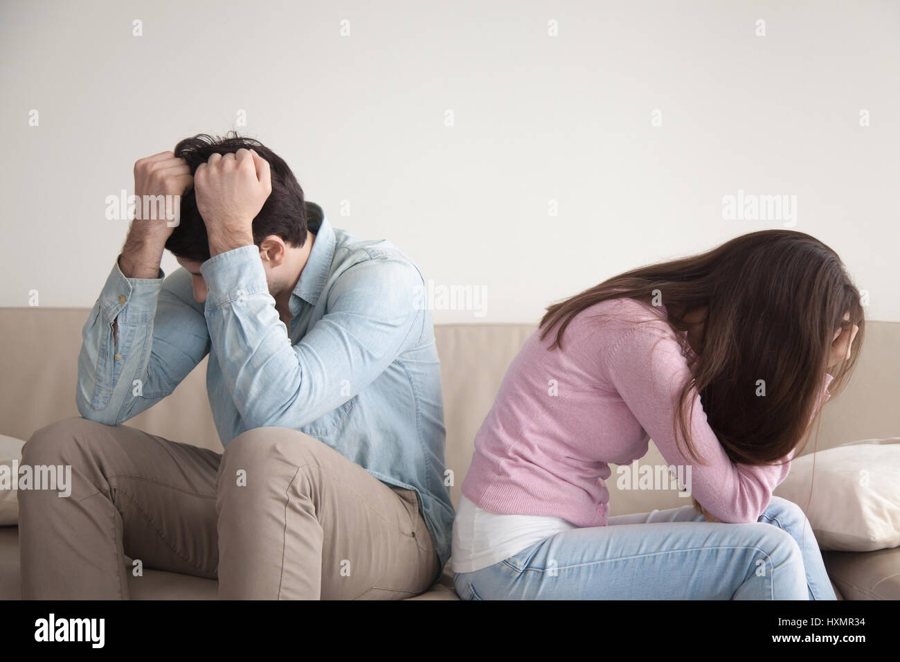 Betonte paar sitzen Rücken an Rücken, Familie und Beziehungen p Stockfoto