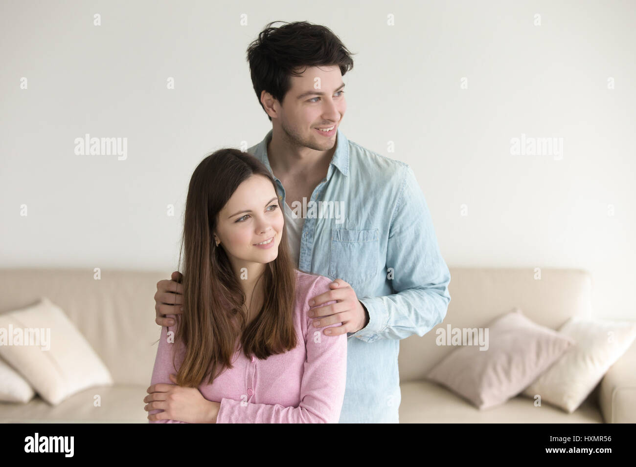 Glückliches junges Paar zu Hause zusammenstehen, lächelnd, auf der Suche Stockfoto