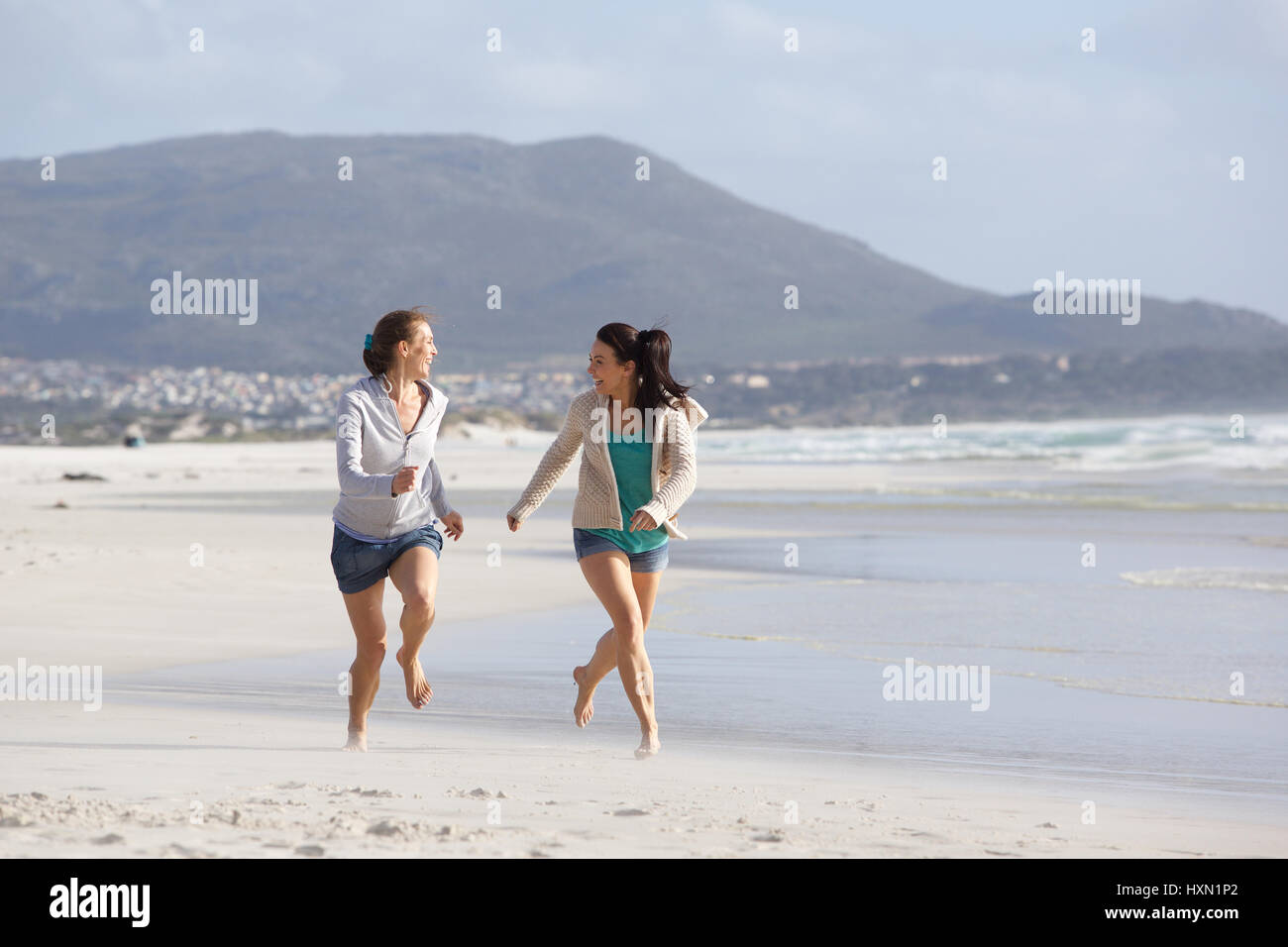 Porträt von zwei Freundinnen zusammen am Strand laufen Stockfoto