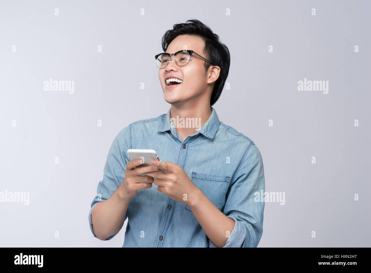 Smart Casual asiatischer Mann mit im Studio Hintergrund smartphone Stockfoto