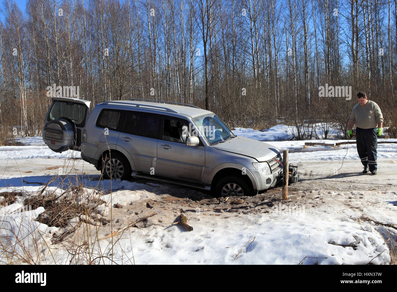 Nazia Village, Leningrad Region, Russland - 17. März 2015: Fahrzeug ist in einem Loch in der Waldstraße Winter stecken, den Treiber zu installieren eine Seilwinde, t zu retten Stockfoto