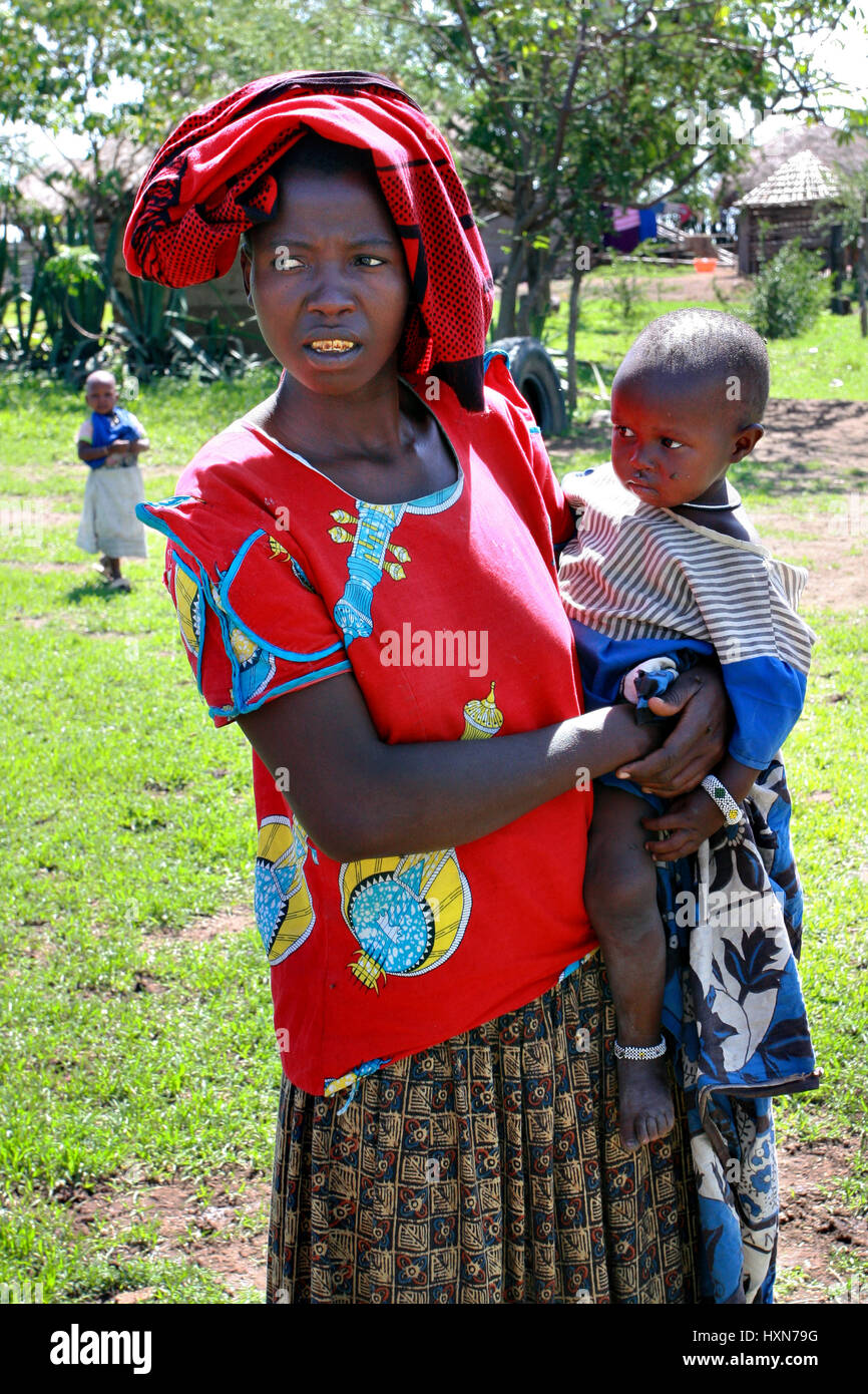 Meserani Snake Park, Arusha, Tansania - 14. Februar 2008: Afrikanische Massai Dorf, eine schwarze Frau in roten Kleidern der humanitären Hilfe, hält auf h Stockfoto