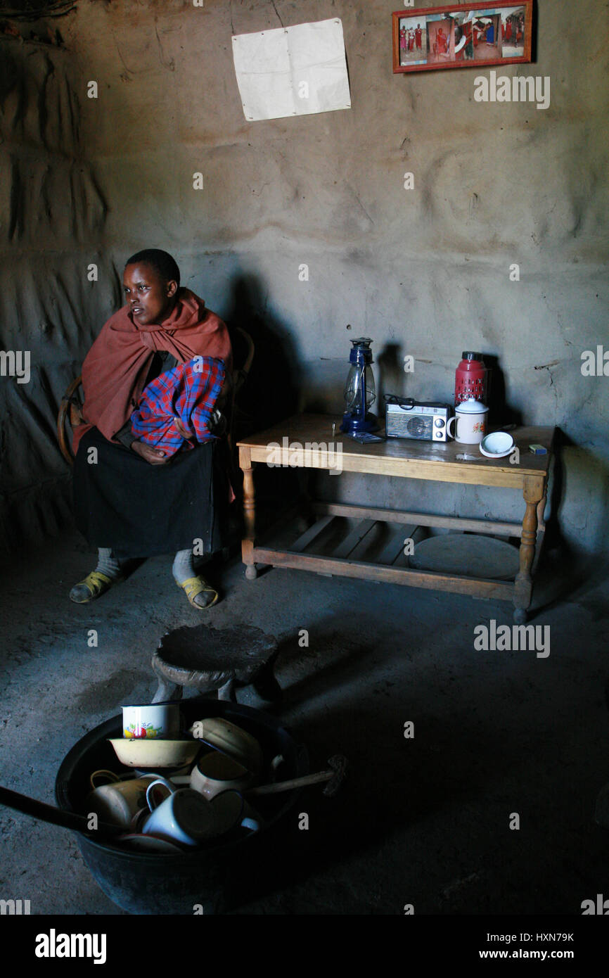 Meserani Snake Park, Arusha, Tansania - 14. Februar 2008: Innenansicht von Heim- und einfache Sachen Menschen afrikanischen Massai Stamm junge Frau sitzen Stockfoto