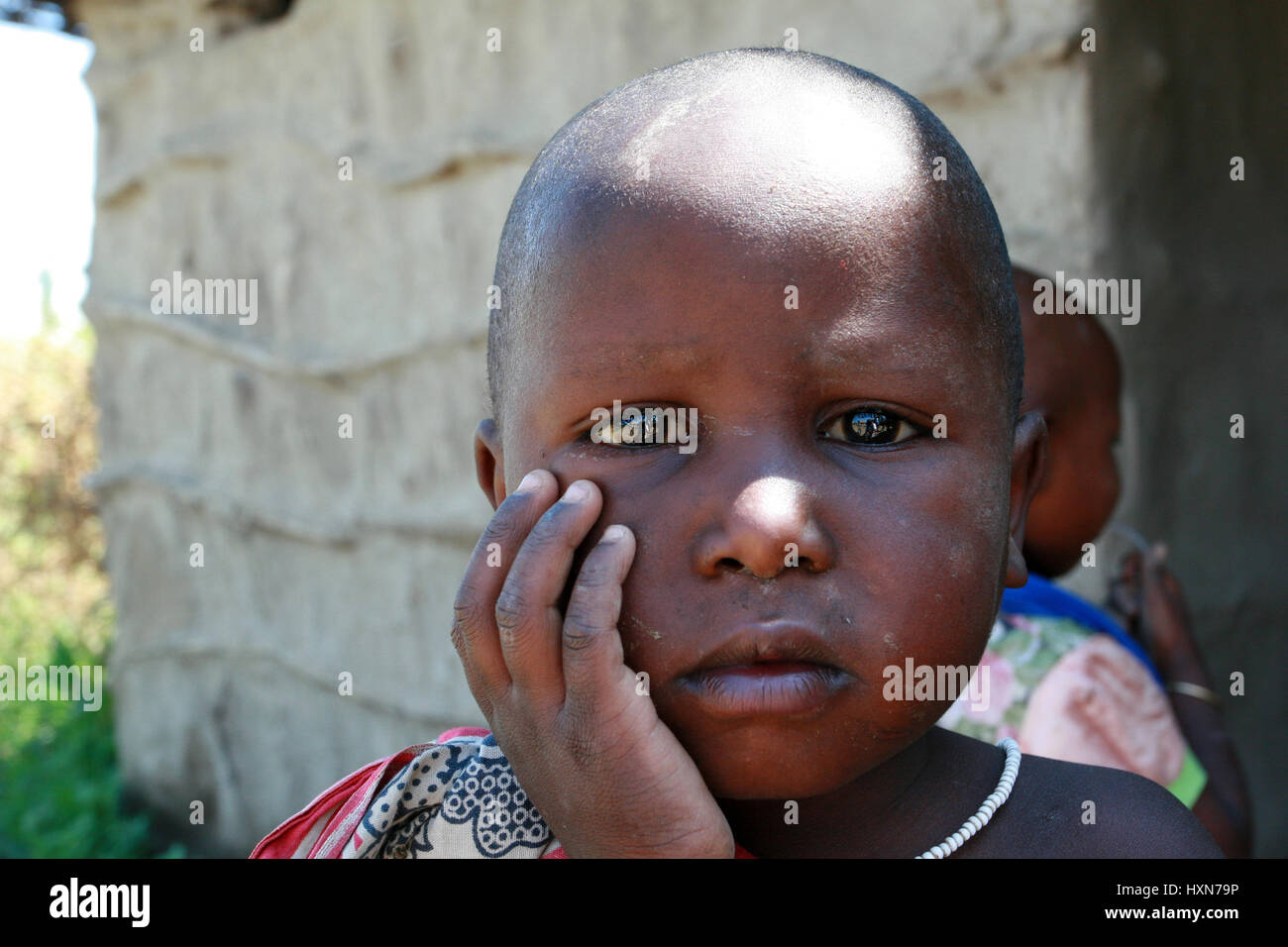 Meserani Snake Park, Arusha, Tansania - 14. Februar 2008: Nahaufnahme Porträt eines unbekannten schwarzen Mädchen drei Jahre alt, mit einem schmutzigen Gesicht, traurig, befindet sich Stockfoto