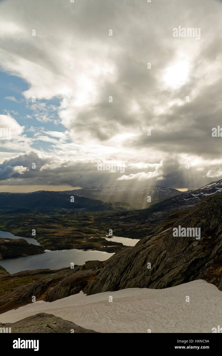 Strahlen von Licht, das durch Wolken in einer bergigen Landschaft im Norden von Norwegen Stockfoto