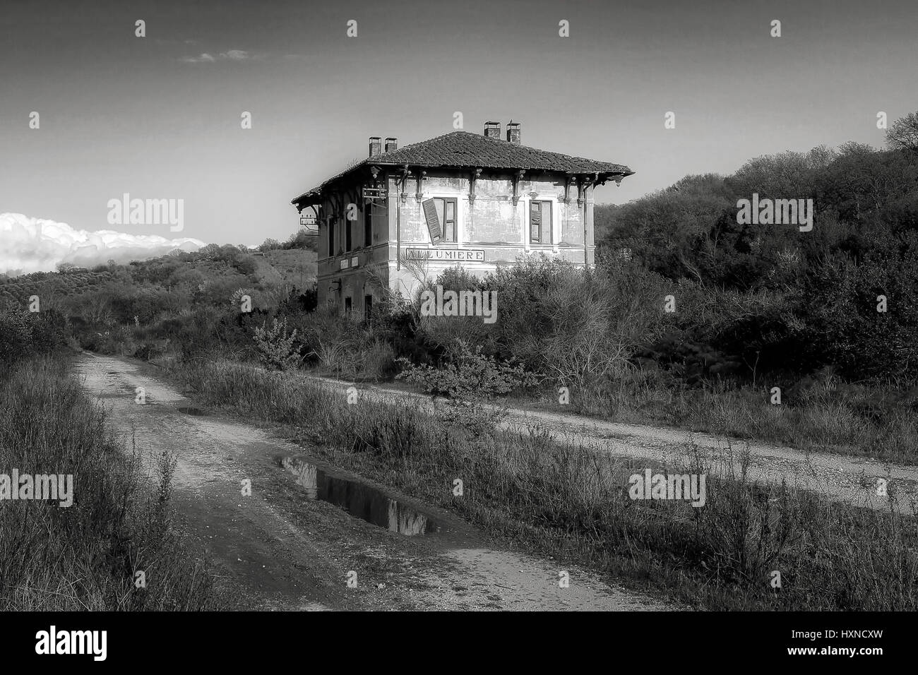 Alten Bahnhof stillgelegten und baufällig, zeichnet sich unter der umgebenden Vegetation. Stockfoto