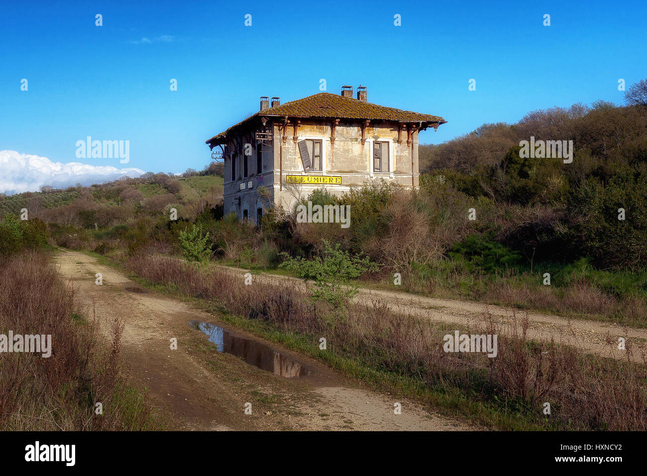 Alten Bahnhof stillgelegten und baufällig, zeichnet sich unter der umgebenden Vegetation. Stockfoto