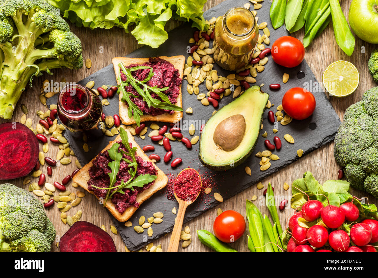 Gesunde vegane Ernährung. Sandwiches und frisches Gemüse auf hölzernen Hintergrund. Detox-Diät. Verschiedene bunte frische Säfte Stockfoto