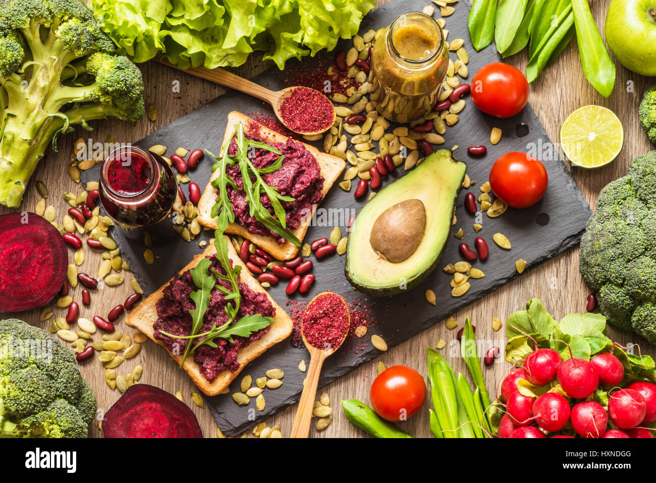 Gesunde vegane Ernährung. Sandwiches und frisches Gemüse auf hölzernen Hintergrund. Detox-Diät. Verschiedene bunte frische Säfte Stockfoto