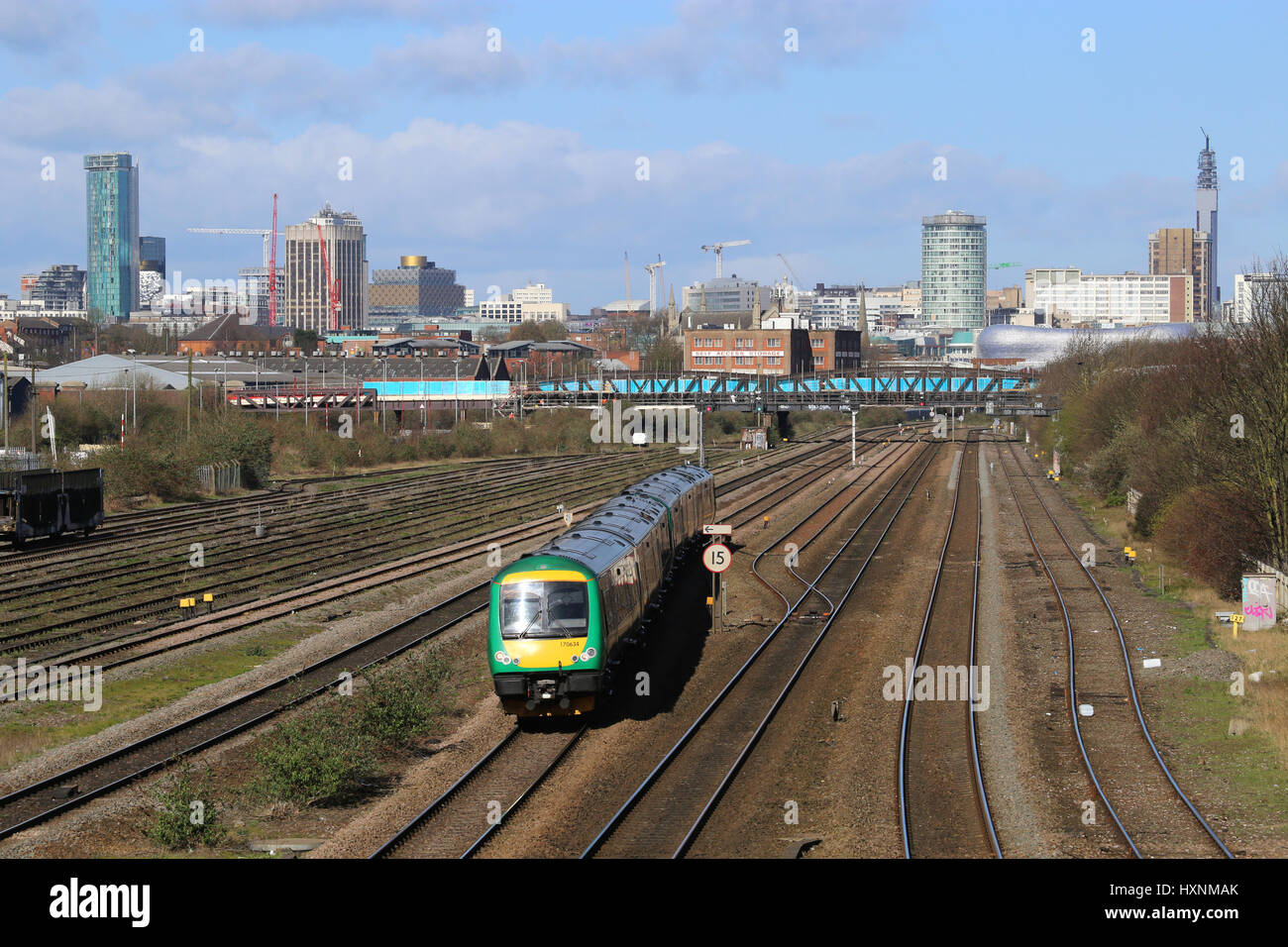 Diesel-Personenzug der Baureihe 170, der aus dem Stadtzentrum von Birmingham, West Midlands, England und Großbritannien fährt, mit Blick auf die Skyline des Stadtzentrums. Stockfoto