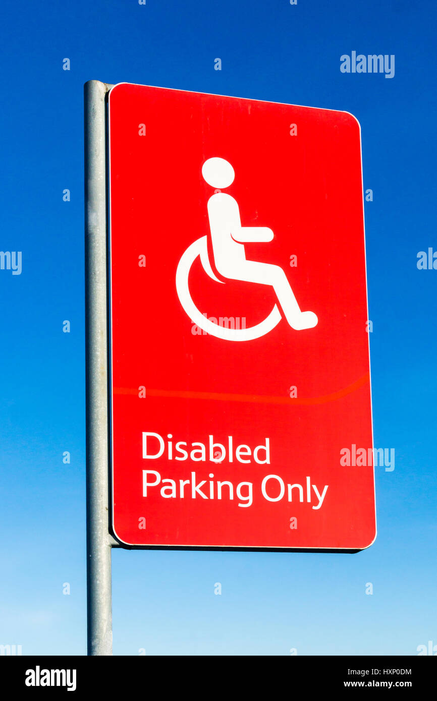 Ein rotes Behinderten Parkplätze nur Schild vor einem strahlend blauen Himmel. Stockfoto