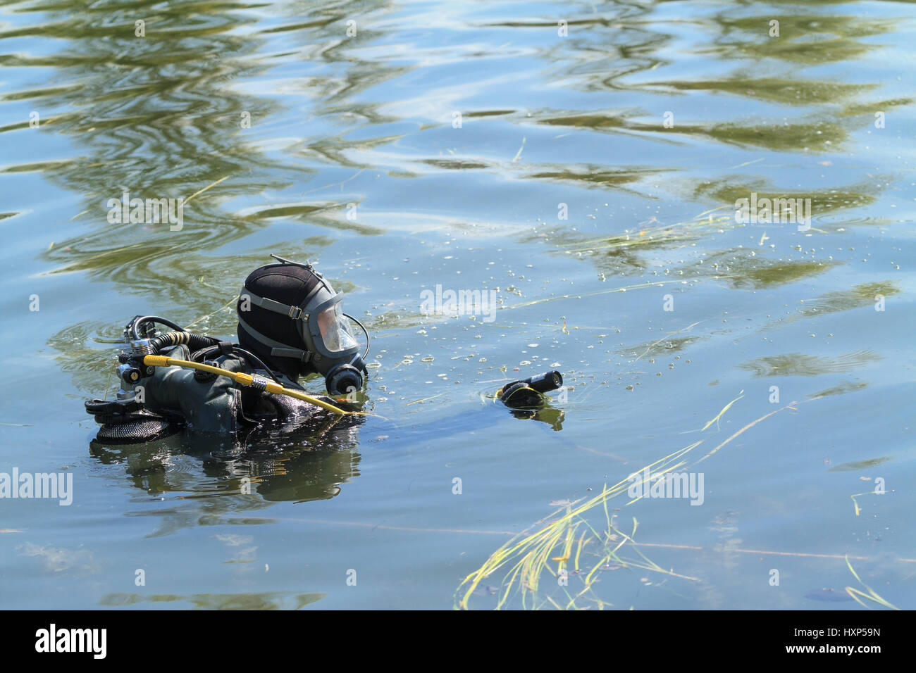 Taucher in Ausrüstung, mit Unterwasser-Kamera führt eine Suche Stockfoto