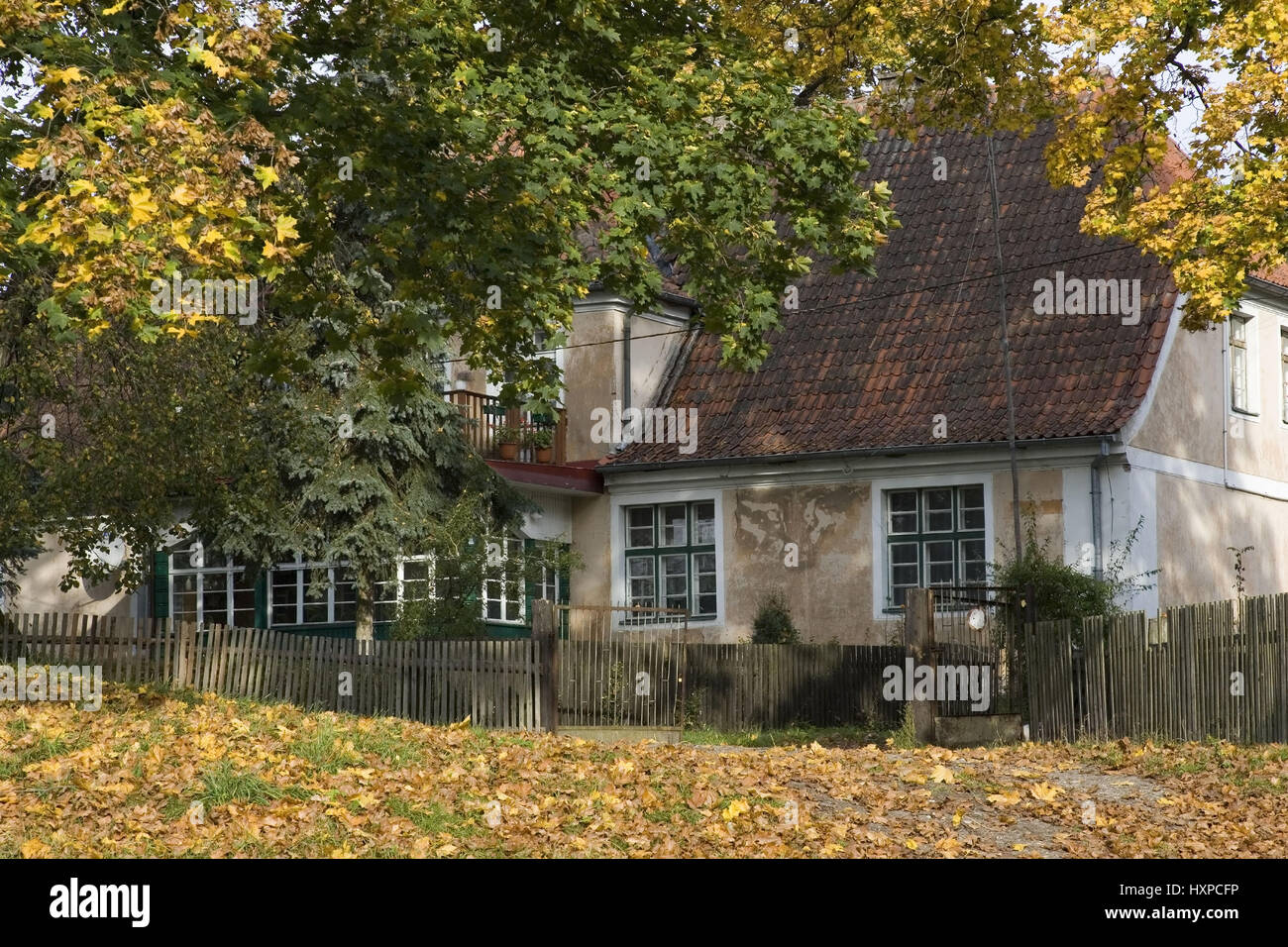 Masurisches Haus mit Herbstkich bunten Laubbäumen. Masuren Polen, Masurisches Haus Mit Herbstkich Verfärbte Laubbäume.Masuren Polen Stockfoto