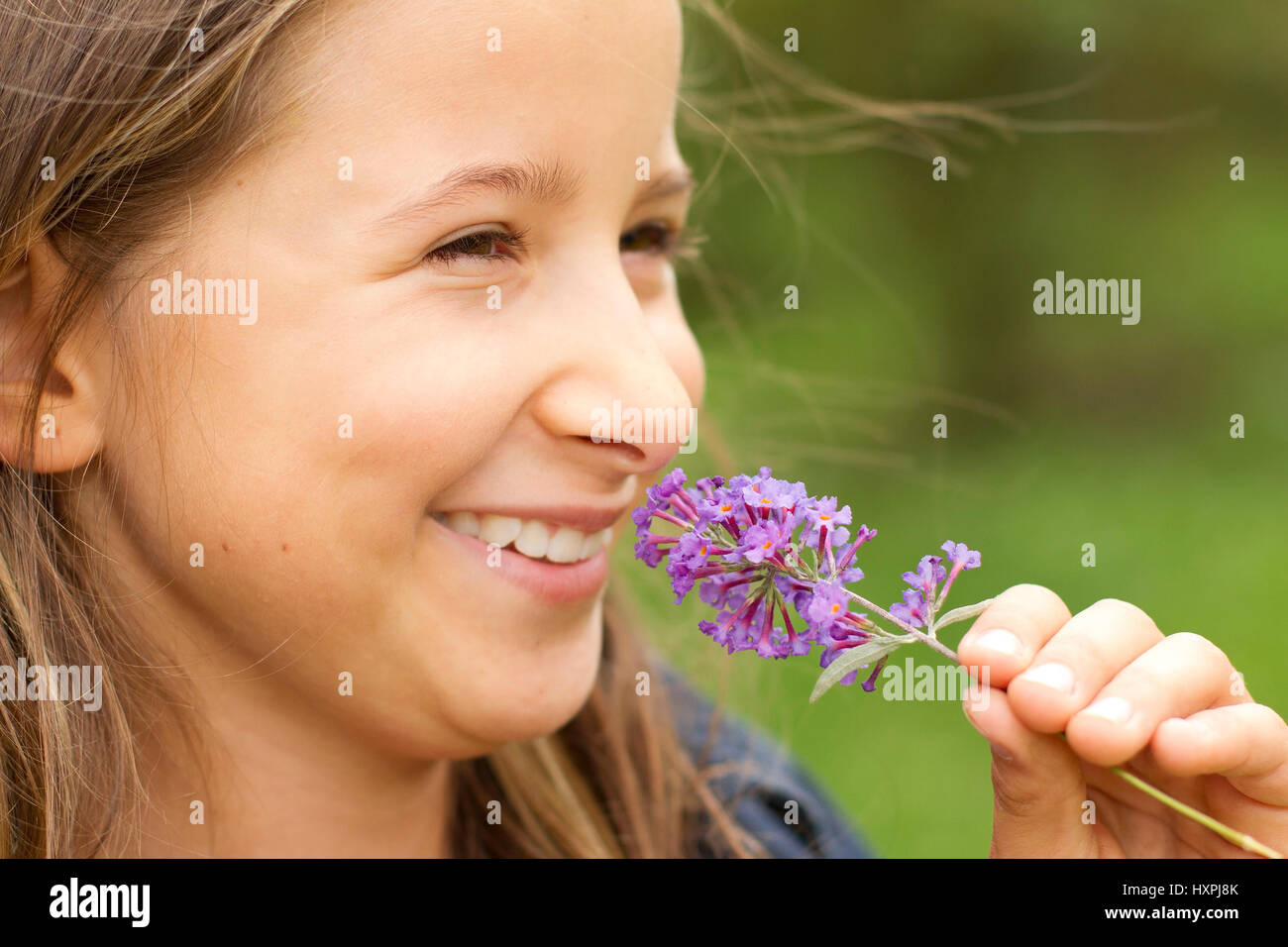 lächelndes Mädchen mit lila, Lächelndes Mädchen Mit Flieder Stockfoto