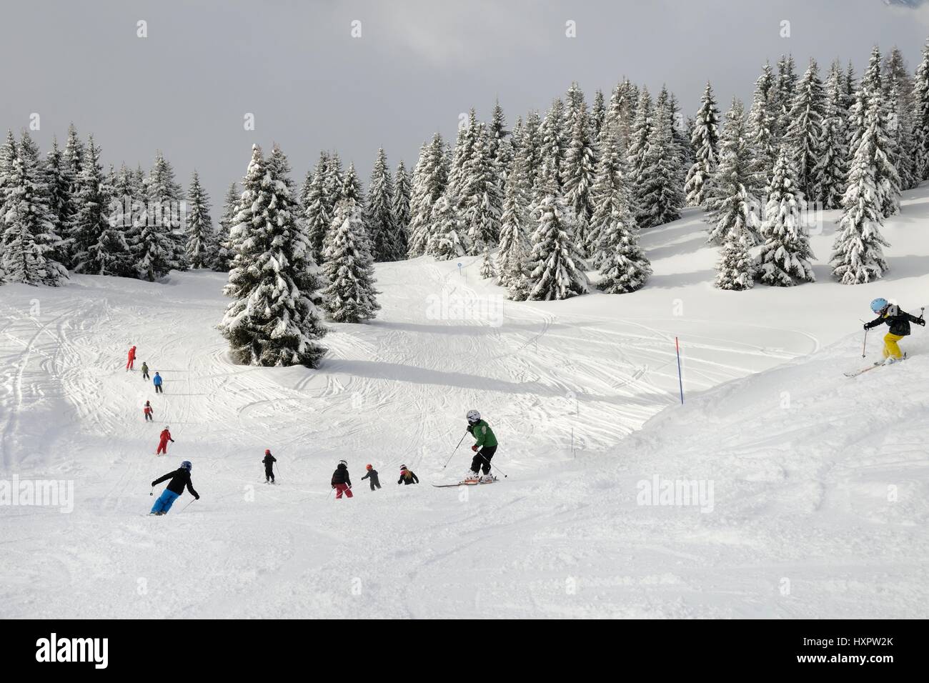Ski Schulgruppe von Kindern nach Lehrer auf einer Piste, Les Houches, Savoie, Frankreich, Februar. Stockfoto