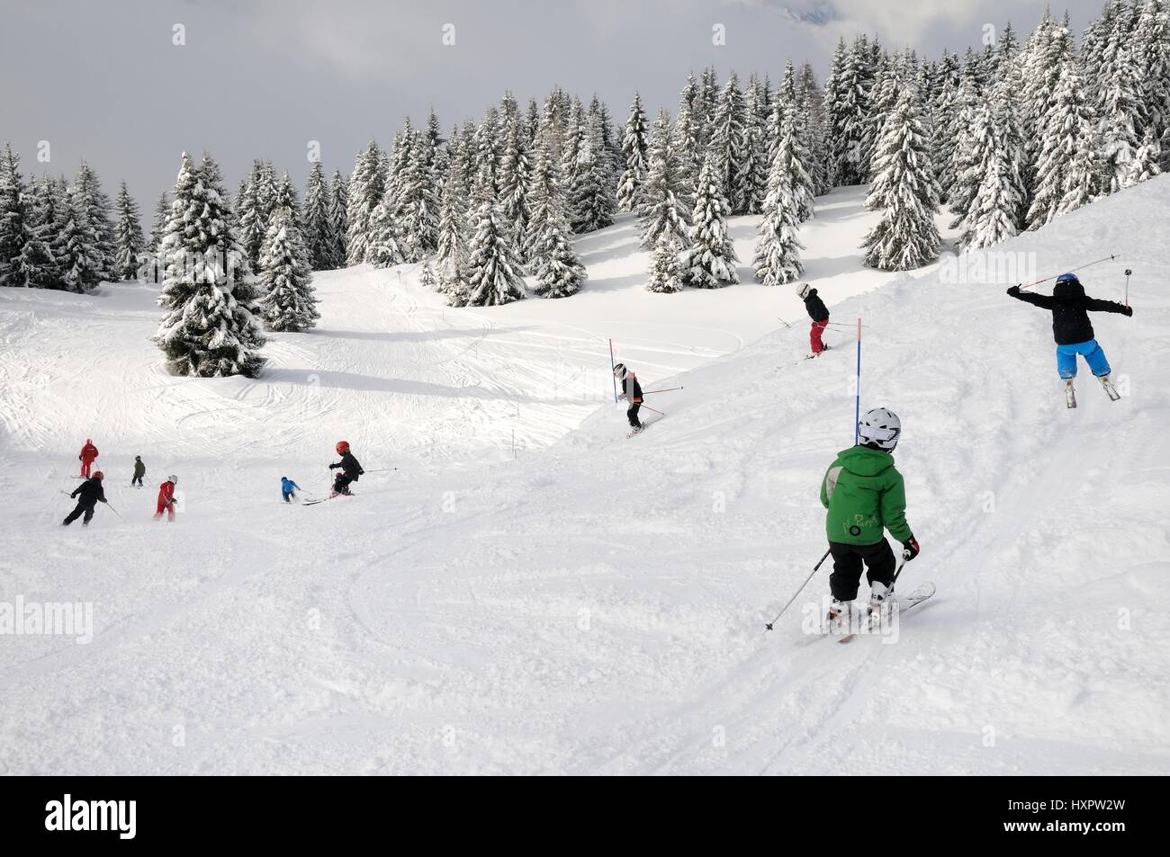 Ski Schulgruppe von Kindern nach Lehrer auf einer Piste, Les Houches, Savoie, Frankreich, Februar. Stockfoto