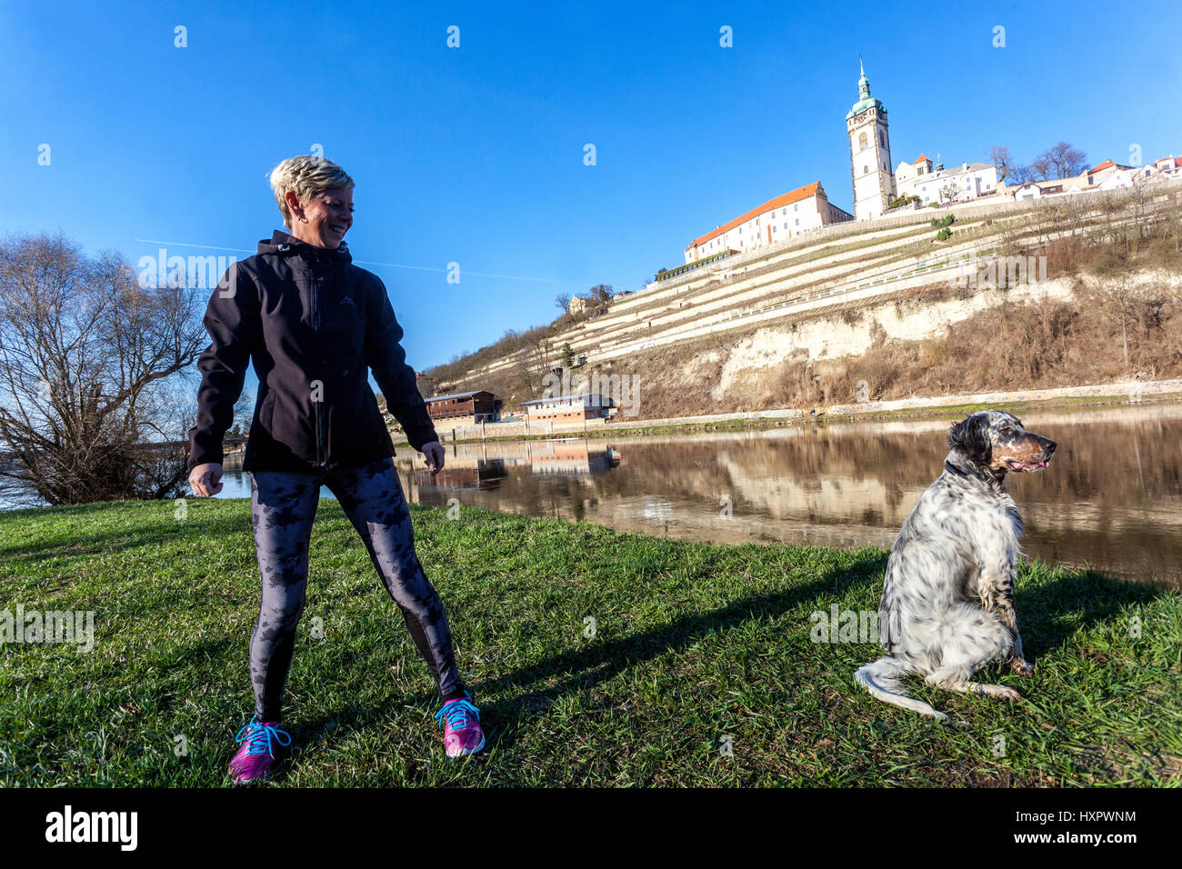 Frau auf einem Spaziergang rund um den Fluss mit ihrem Irish Red Setter, Melnik Burg im Hintergrund, Tschechische Republik, Europa Stockfoto