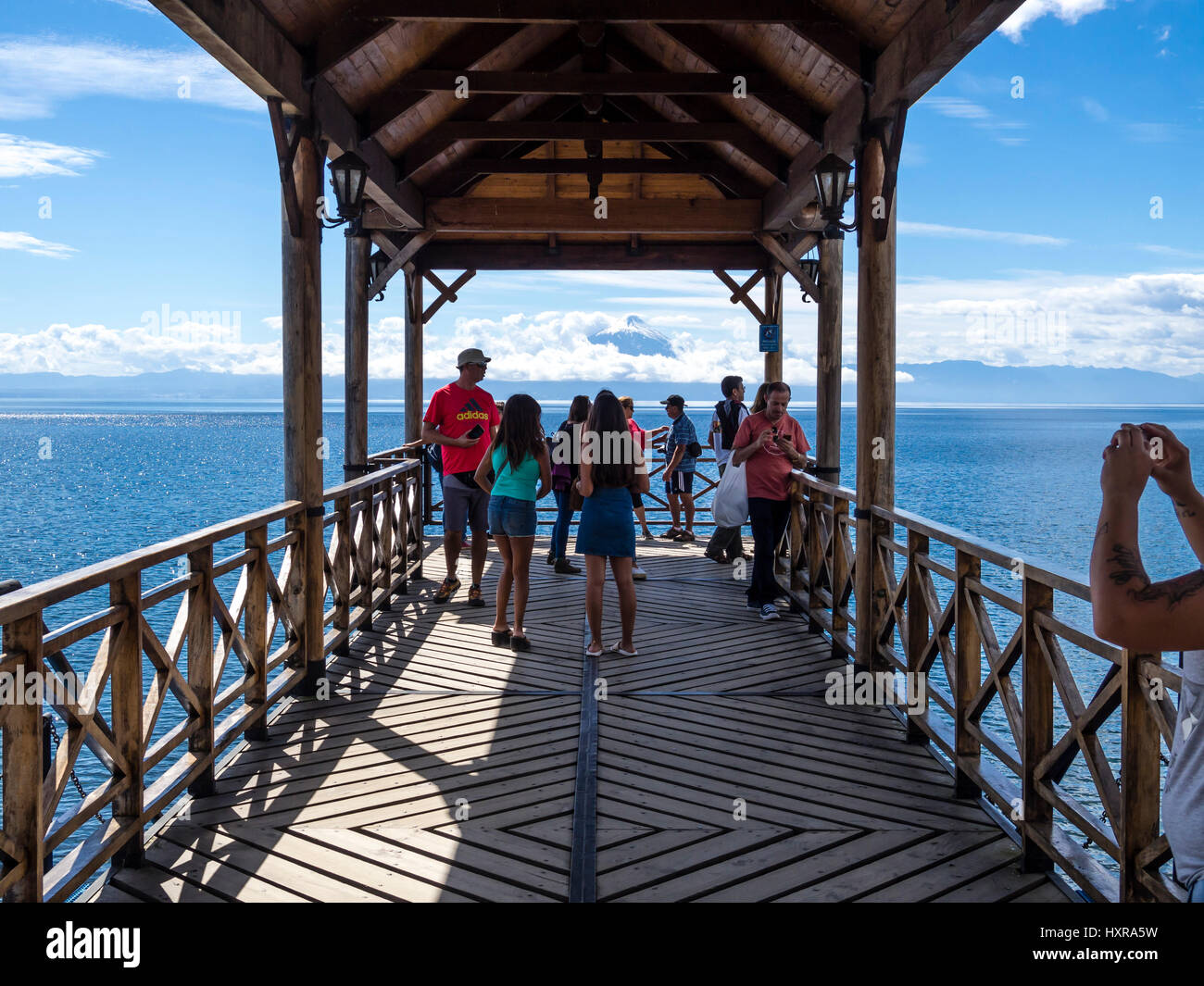 Blick auf Pier in Richtung Vulkan Osorno, Touristen auf der Pier fotografieren, Frutilliar, Dorf am See Lago Llanquihue, chilenische Seenplatte, Chi Stockfoto