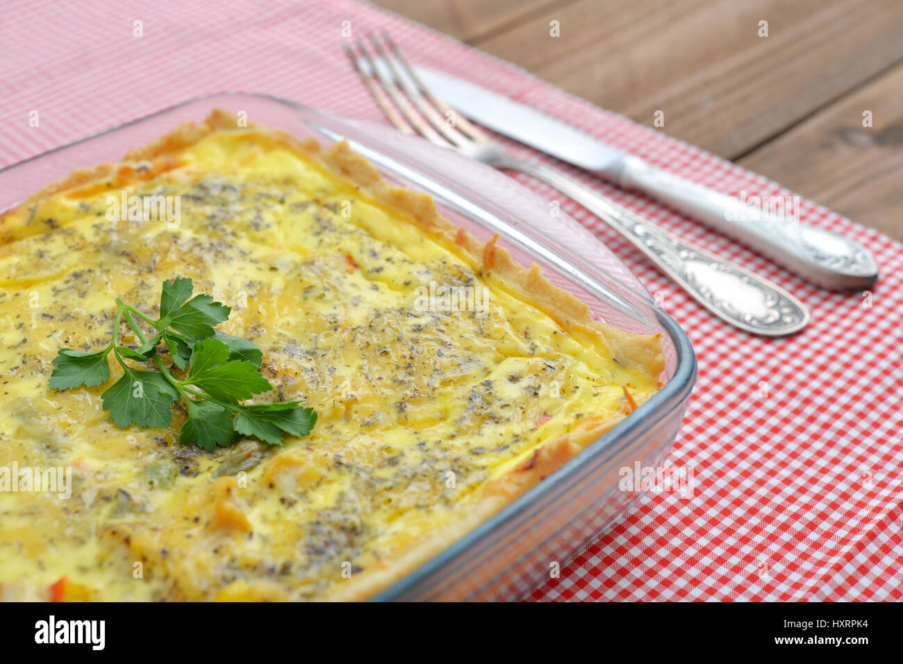 Quiche Lorraine im quadratischen Backform auf hölzernen Hintergrund Stockfoto