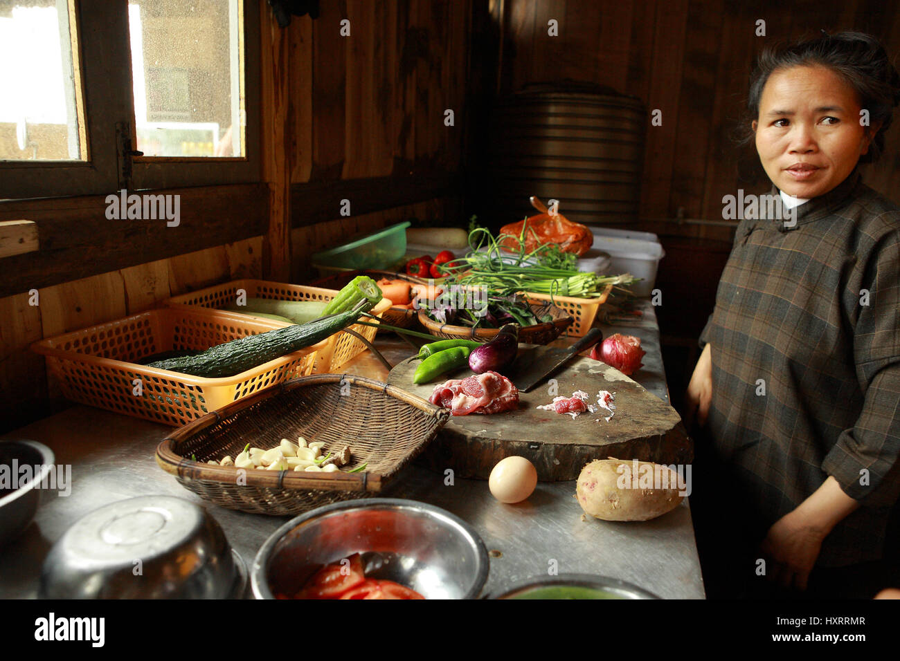 Guizhou, China - 10. April 2010: Küche Restaurant in südwestlichem China, asiatische Frau stand in der Nähe ein Tisch mit Speisen, traditionelle chinesische di Kochen Stockfoto