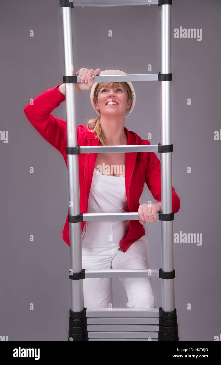 Frau eine Aluminium-Teleskop-Leiter klettern Stockfoto