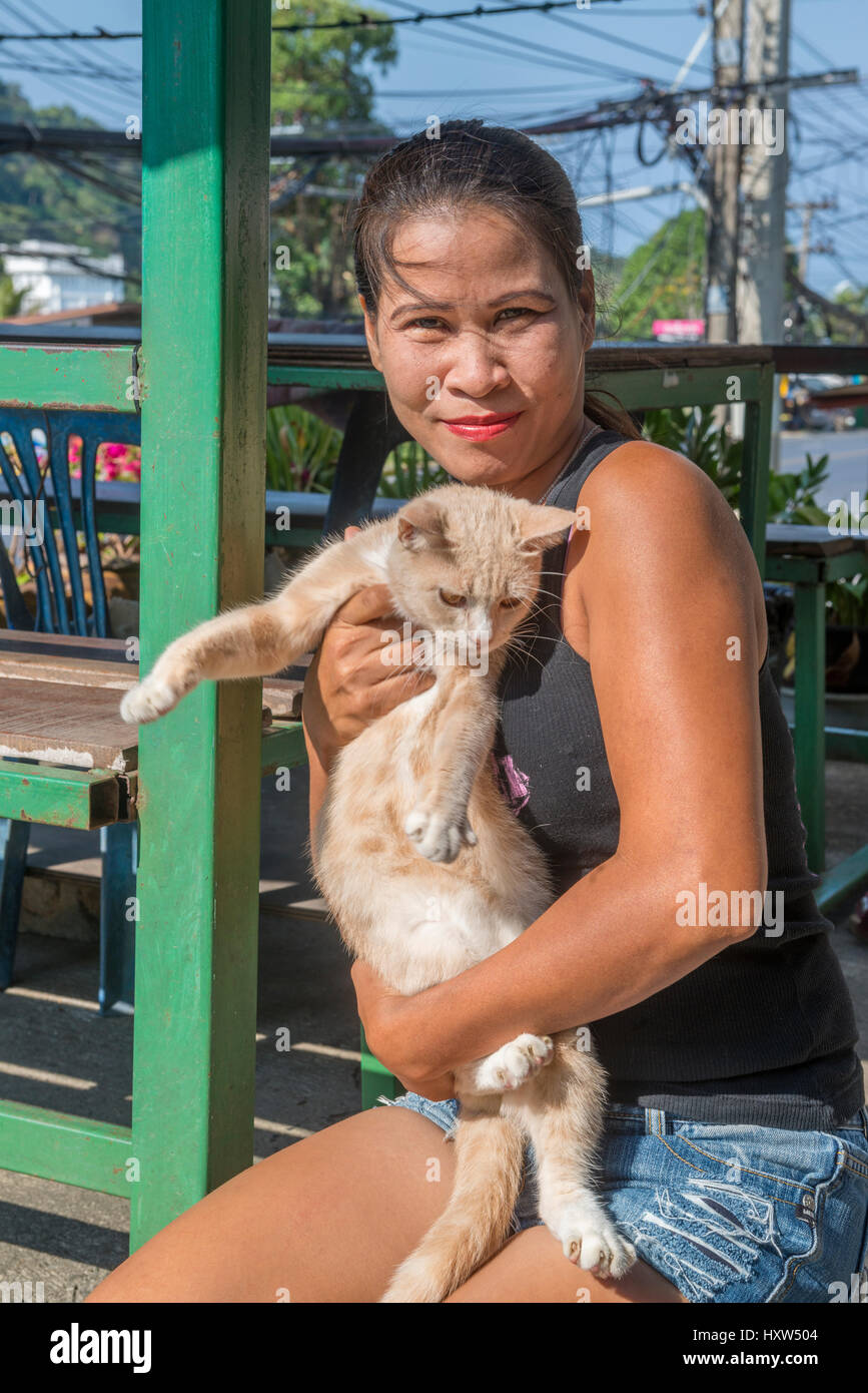 Eine Thai Dame hält eine Katze in Phuket, Thailand. 9. März 2017 Stockfoto