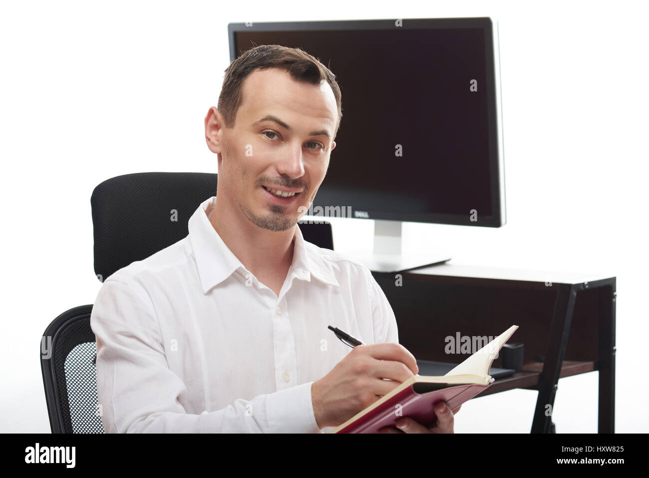 Mann mit Hinweis buchen in weißen Office-Hintergrund. Lächelnder Mann schreiben Hinweis Stockfoto