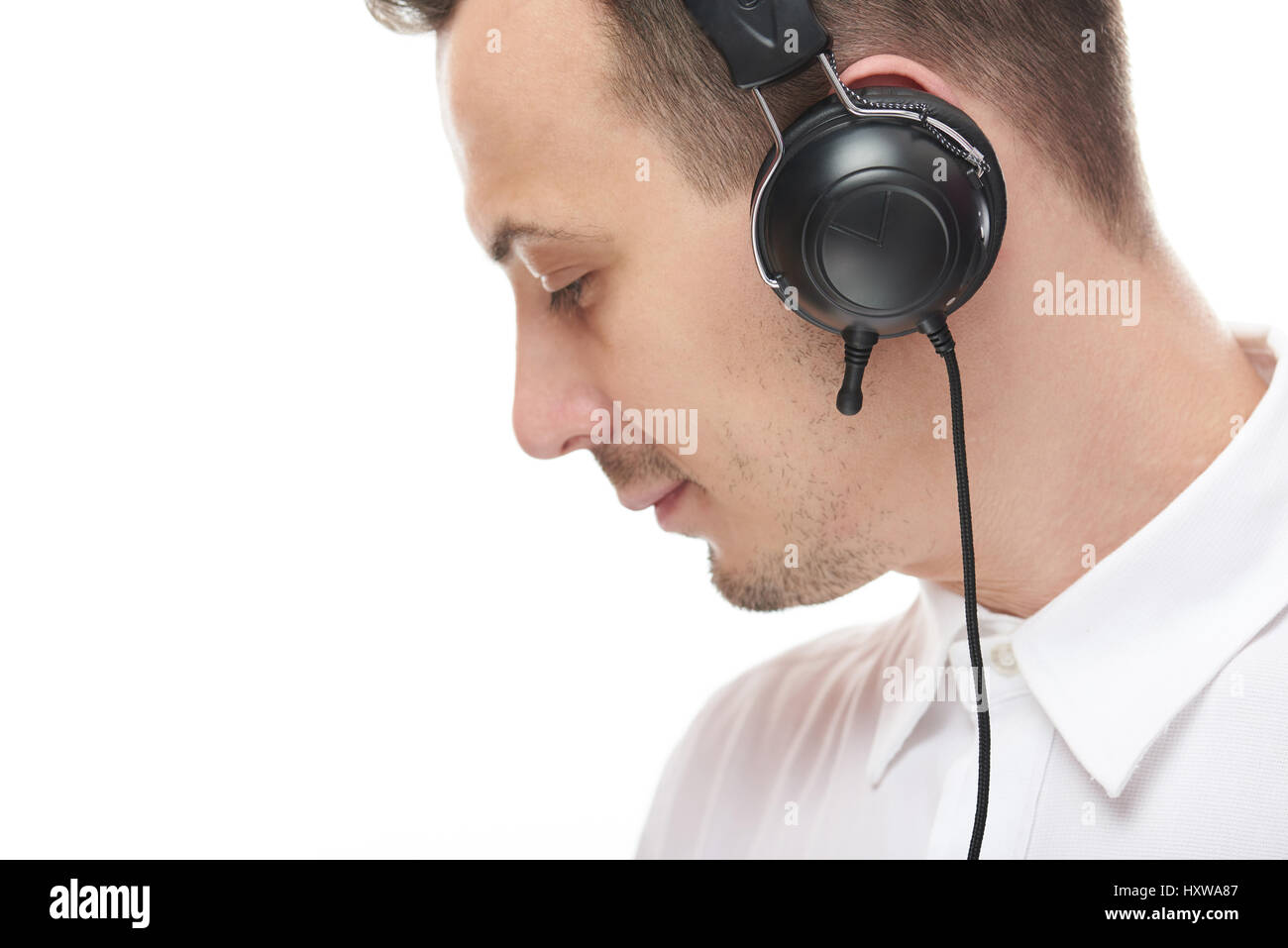 Seite anzeigen Mann mit Kopfhörer isoliert auf weißem Hintergrund. Junger Geschäftsmann mit Kopfhörer Stockfoto