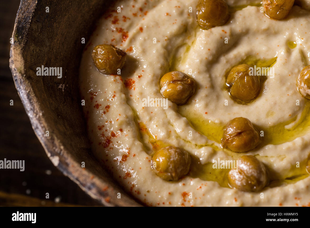 Hausgemachter Kichererbsen Hummus in rustikalen Schüssel mit Olivenöl und frischem Fladenbrot Stockfoto