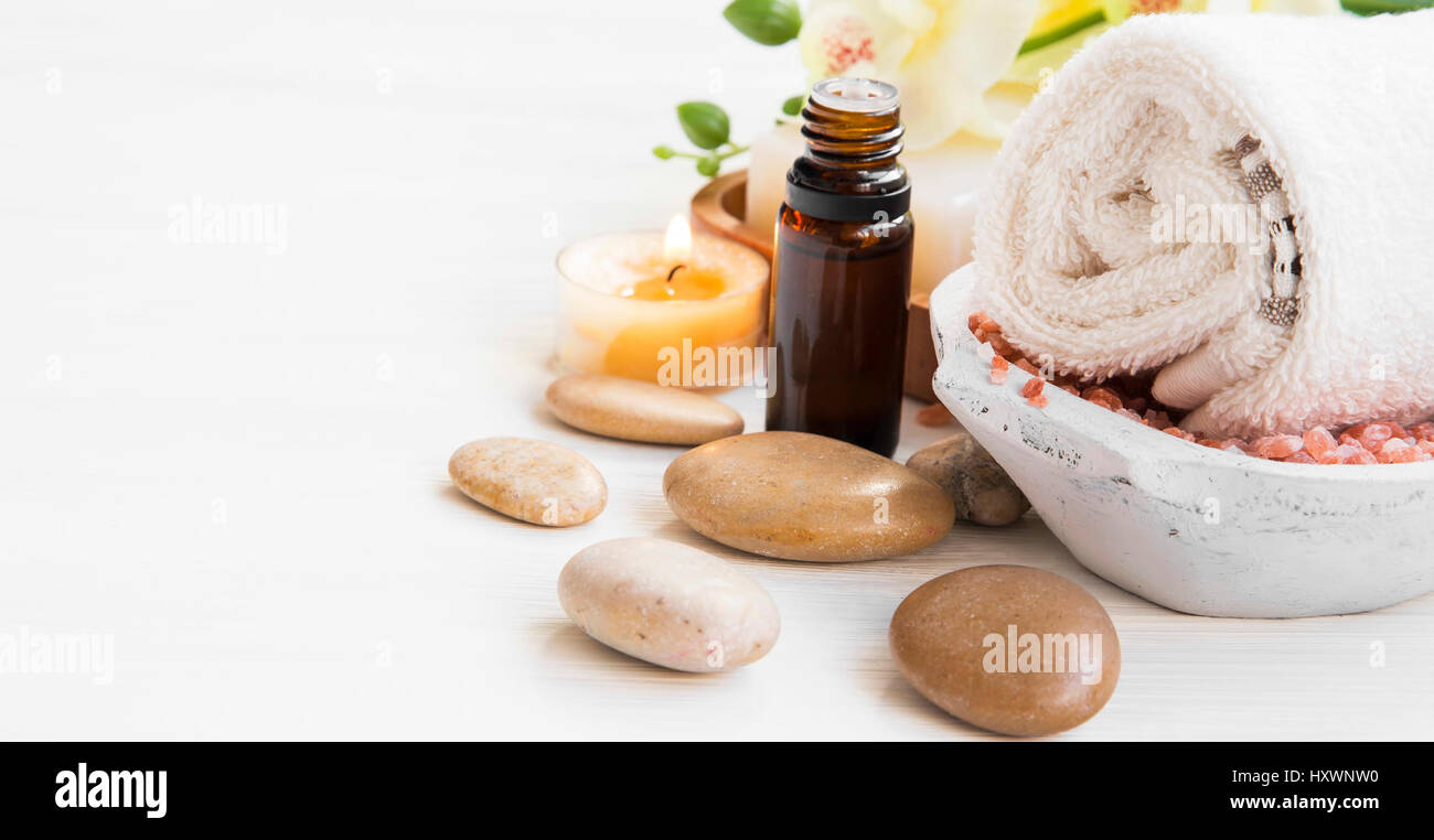 Spa-Einstellung mit Essenz Flasche, Baumwolltuch, massage, Steinen und Kerze Stockfoto