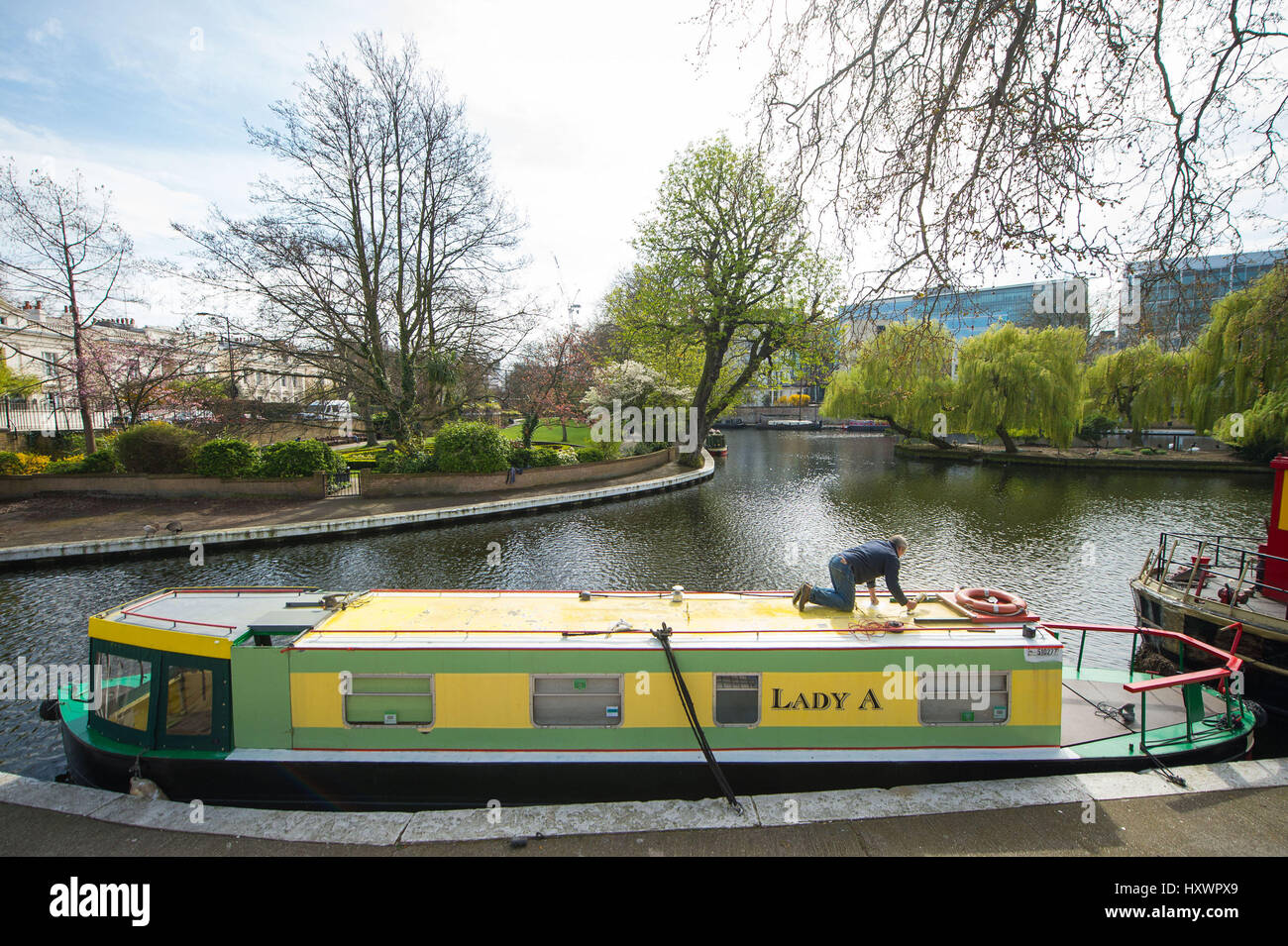 Ein Mann arbeitet auf einem Narrowboat in Klein-Venedig, London, an einem Tag bei Temperaturen im Südosten von England erwartet wurden, um saisonale überdurchschnittlich hoch und erreichen 22 C. Stockfoto