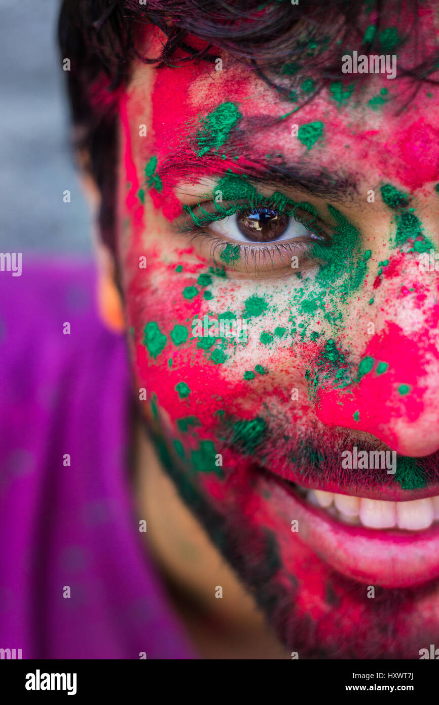 Halbes Gesicht Porträt eines jungen Mannes mit Farben bedeckt, während das Fest der Farben, Holi in Indien. Stockfoto
