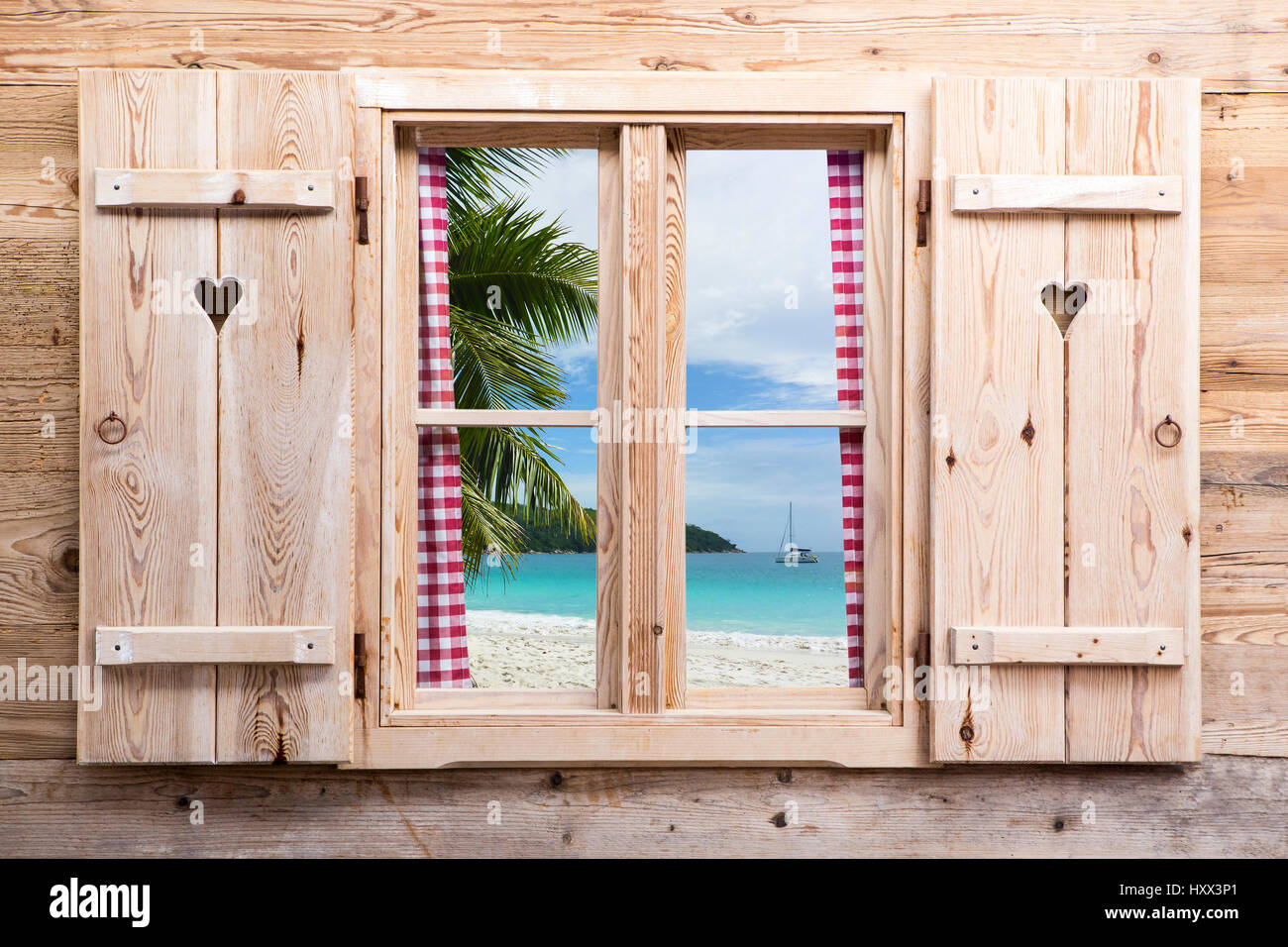 Holzfenster mit Panoramablick Sonnenstrand, Reisekonzept Stockfoto