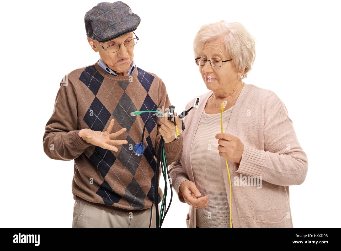 Verwirrt Senioren Blick auf verschiedene Arten von elektronischen Kabel isoliert auf weißem Hintergrund Stockfoto