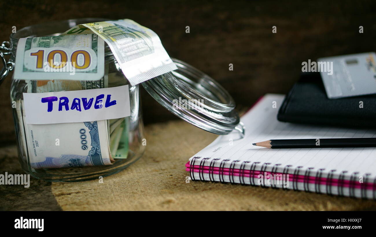 Geld sparen für die Reise auf dem Holz Schreibtisch und Natur Hintergrund mit weißen notebook Stockfoto
