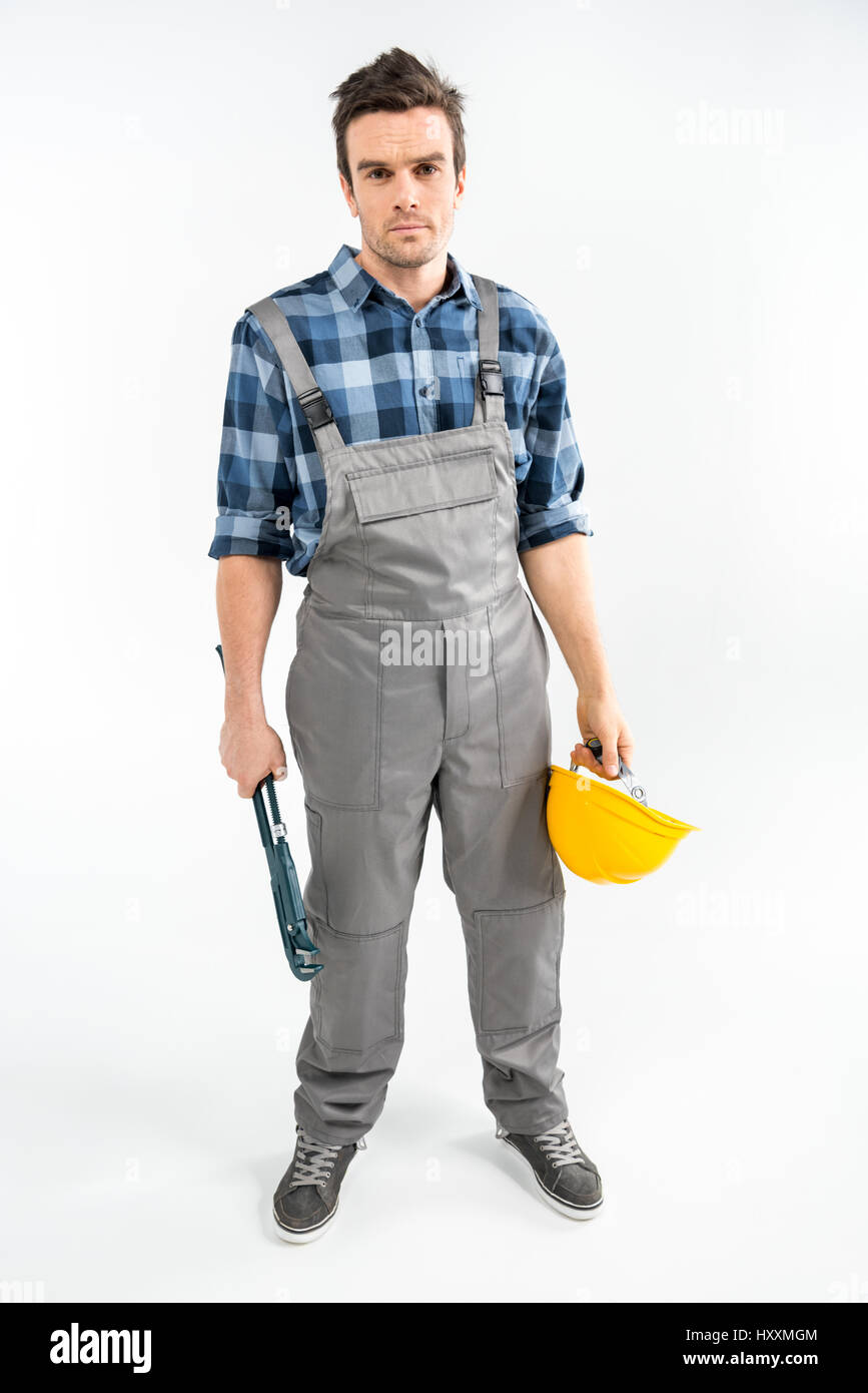 Professionellen männlichen Bauarbeiter mit Rohrzange und Schutzhelm Stockfoto
