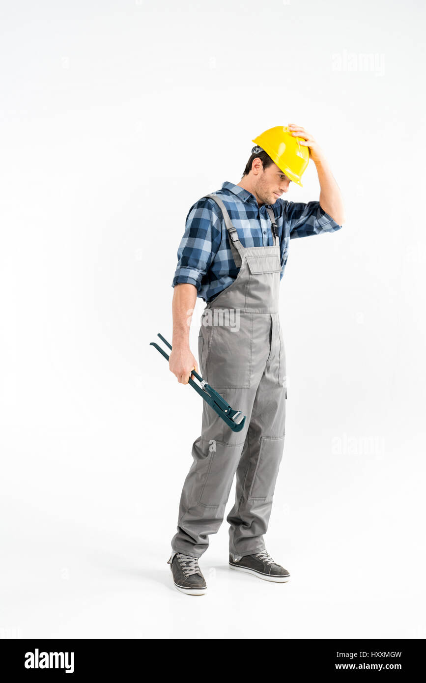Professionellen männlichen Bauarbeiter mit Rohrzange und Schutzhelm Stockfoto