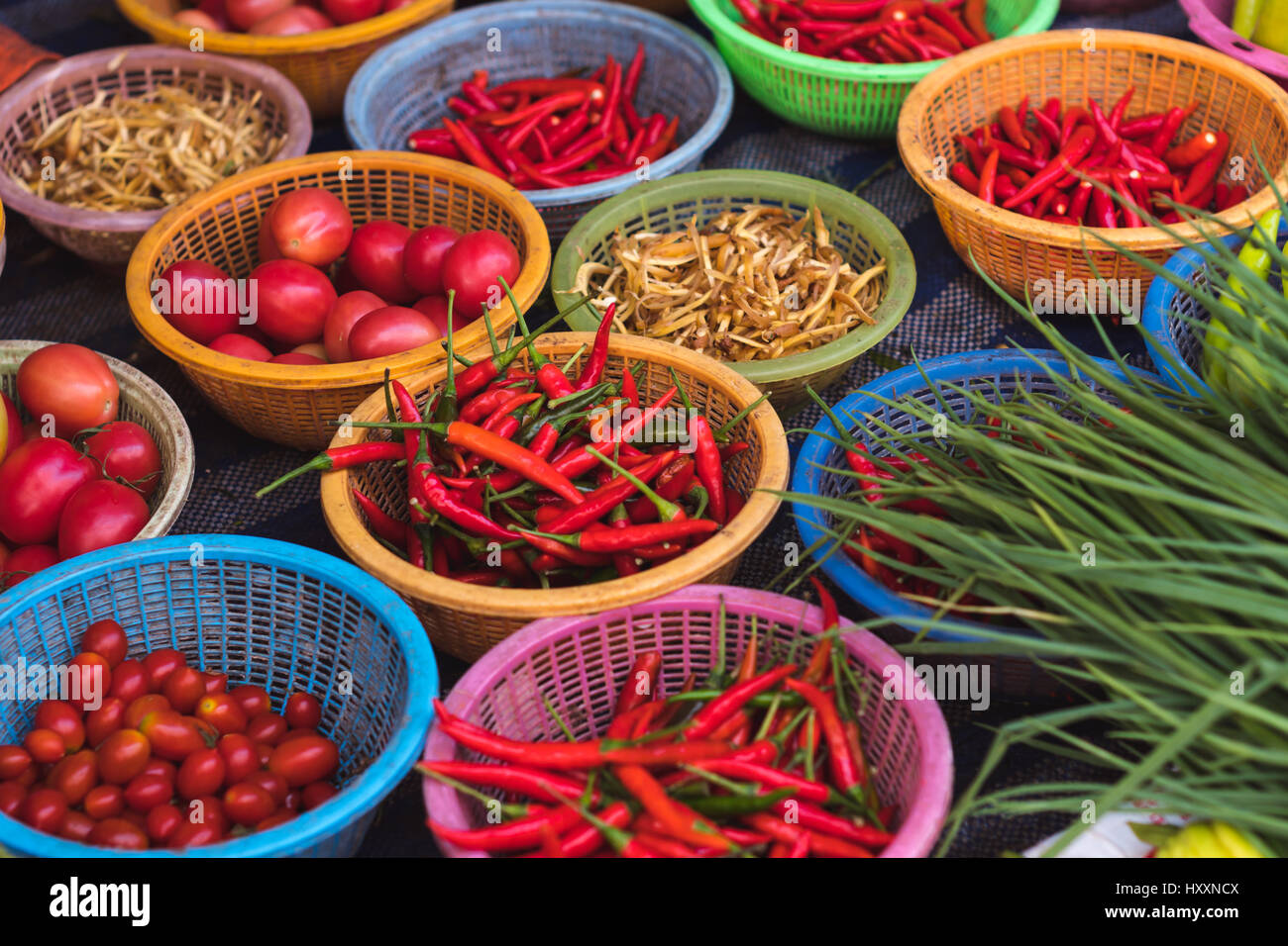 Vielzahl von bunten Paprika, Tomaten, Ingwer und grünen in Körbe zum Verkauf an lokale Morgenmarkt in Sattahip, Thailand Stockfoto
