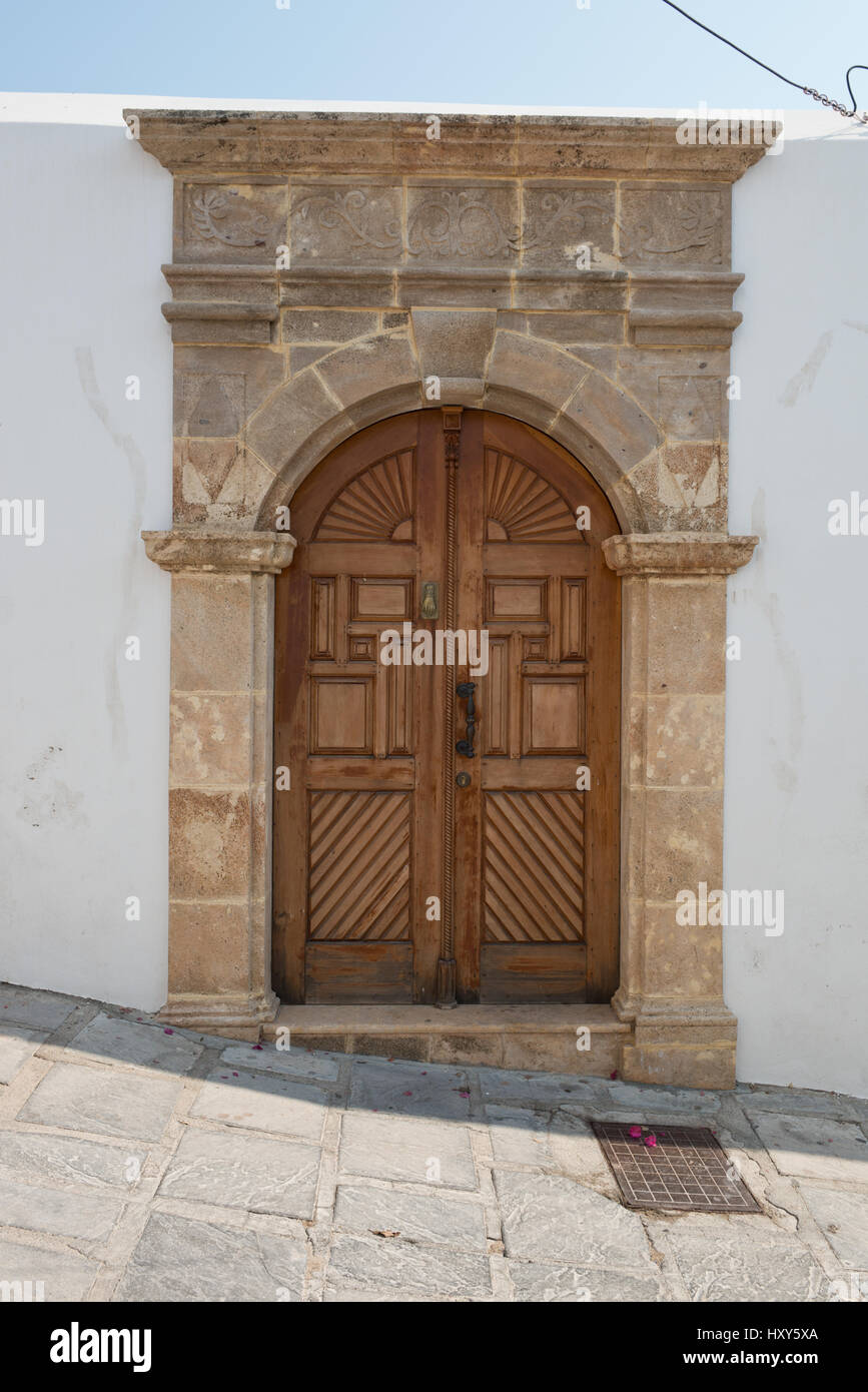 Portal eines alten Hauses mit braunen Tür und Sandstein Holzrahmen in das Dorf Lindos, Rhodos, Griechenland Stockfoto