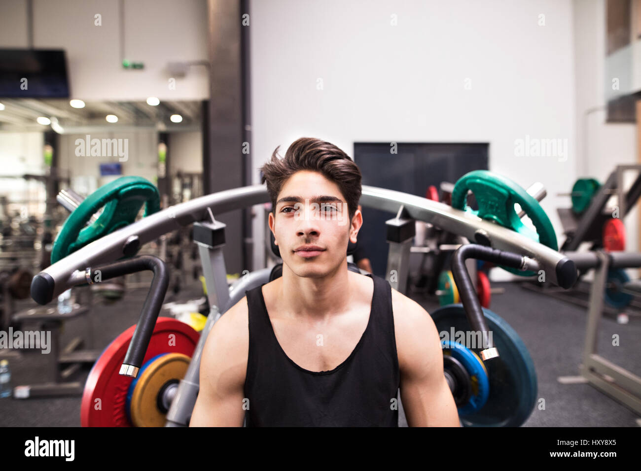 Junge fit hispanic Mann im Fitness-Studio gehen, um am Fitnessgerät trainieren, Muskeln. Bodybuilder Training vorbereitet Presse Schulter wollen. Stockfoto