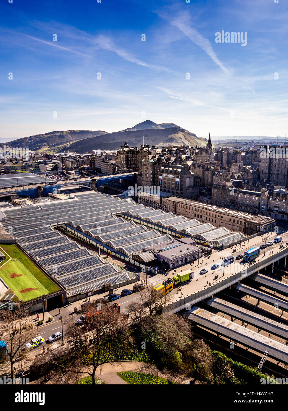Glasplatzdächer der Edinburgh Waverley Station mit Waverley-Brücke im Vordergrund und Salisbury Crags und Arthur's Seat in der Ferne. Stockfoto