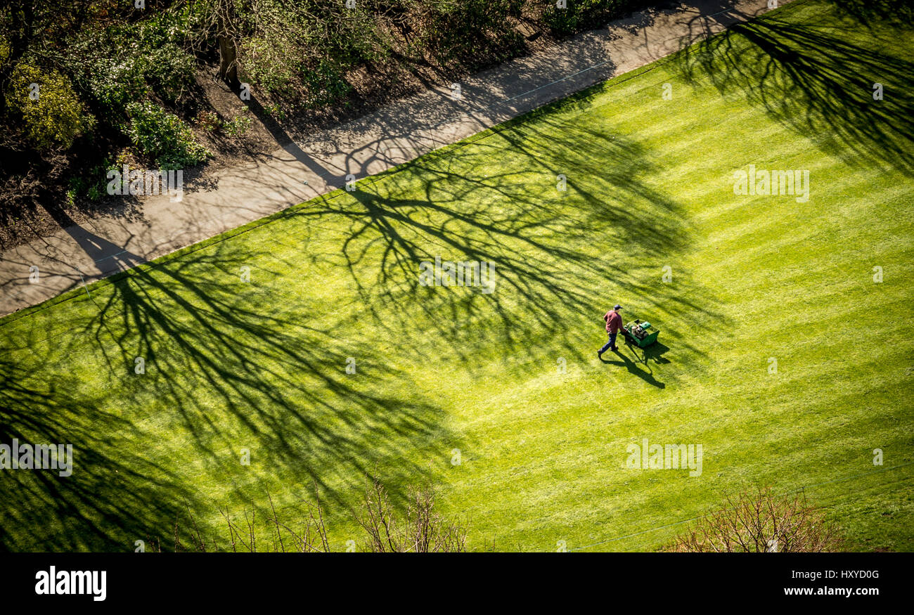 Luftaufnahme eines Gärtners, der mit einem Benzinmäher den Rasen der Princes Street schneidet. Edinburgh. Stockfoto