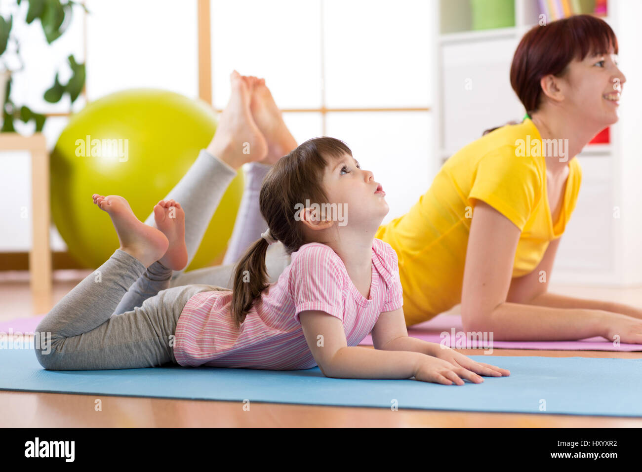 Mutter und Tochter Gymnastik-Übungen auf Matte zu Hause. Stockfoto