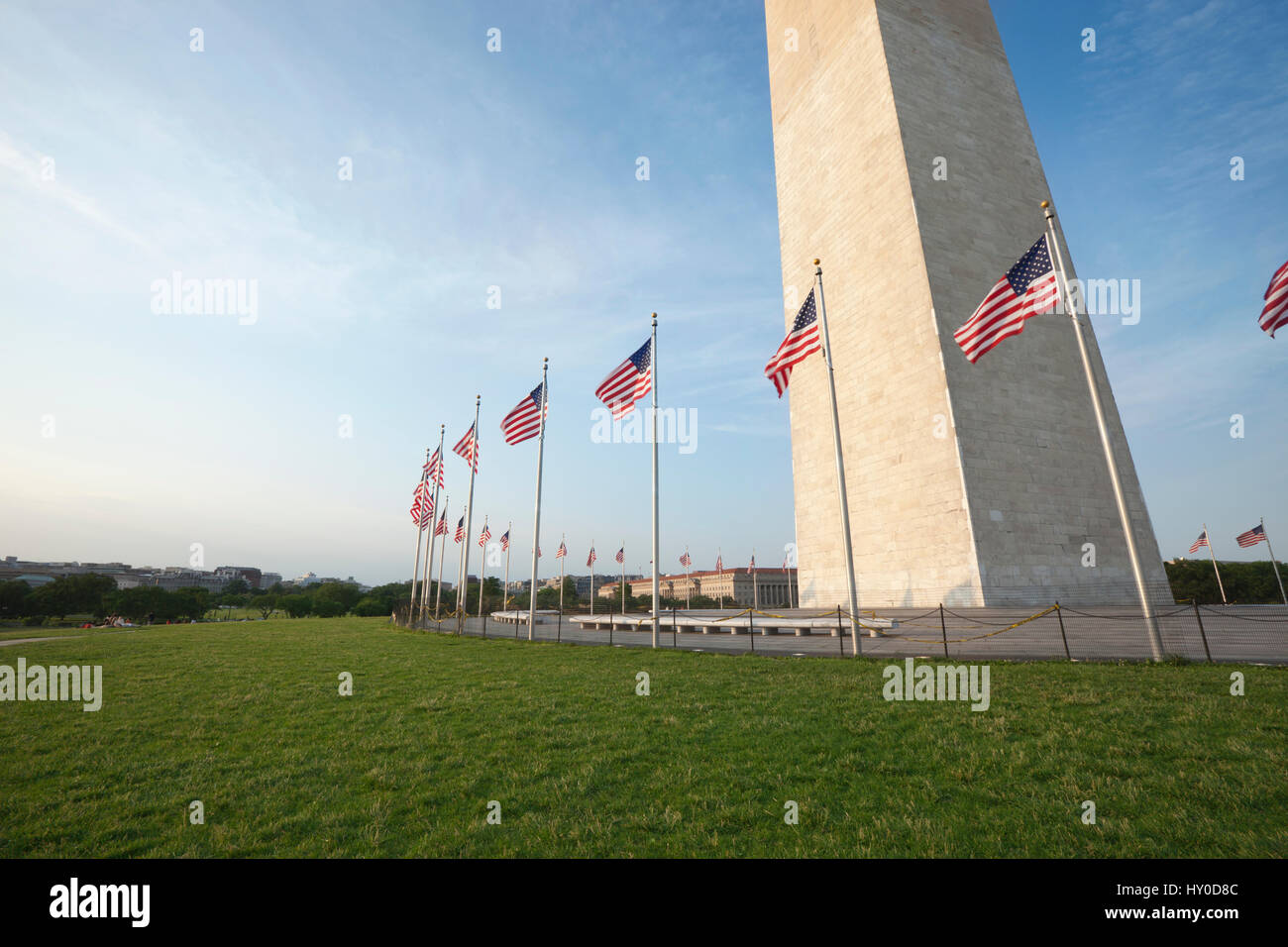 Weitwinkel-Blick auf das Washington Monument mit amerikanischen Fahnen an der Basis Stockfoto