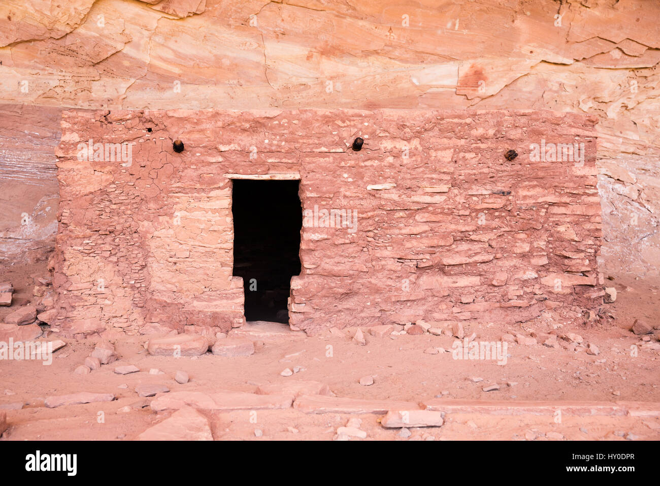 Eine t-förmige Tür in einer dunklen Wohnung von den Pueblo-Menschen in der Wüste Südwesten gebaut. Es ist eine kleine Backsteingebäude erstellte vor Tausenden von Jahren eine Stockfoto