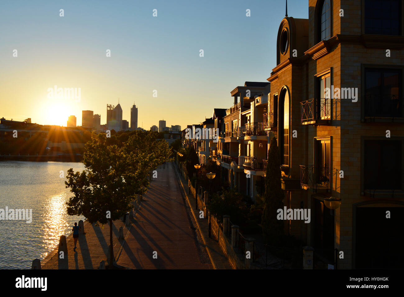 Die untergehende Sonne beleuchtet Claisebrook Cove, in Perth, Western Australia. Die Hochhäuser von Perth sind im Hintergrund abhebt. Stockfoto