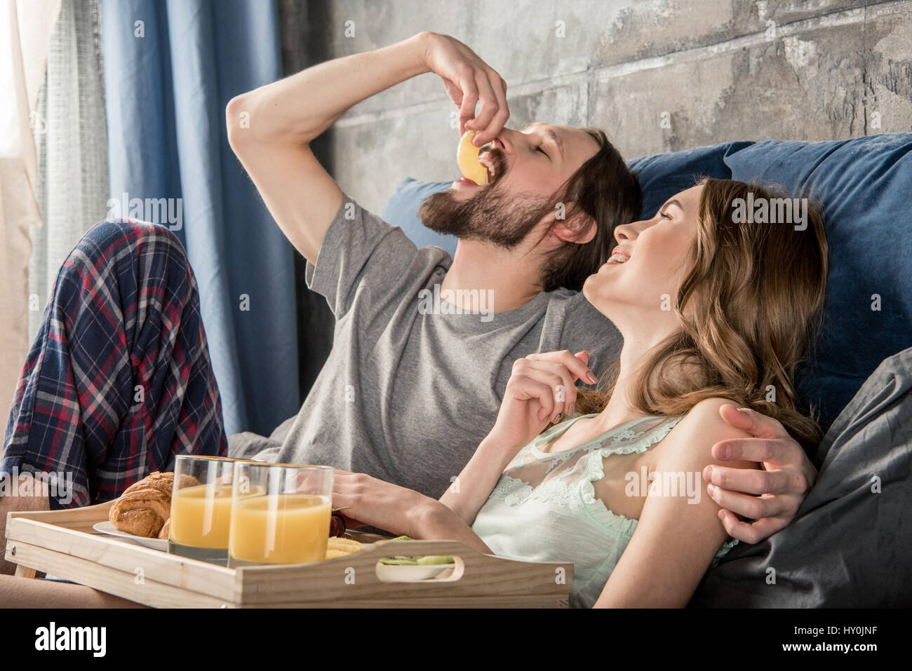 Junges Paar entspannt hat das Frühstück im Bett Stockfoto